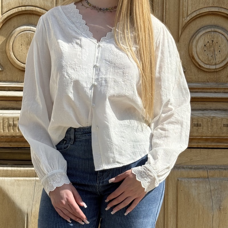 Femme portant un chemisier blanc bohème et un jean, style élégant et naturel